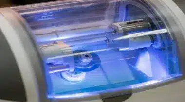 UV sterilization cabinet with blue light illuminating dental instruments inside.